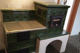 Kachlový sporák, ručně vyráběné kachle zelené barvy, prosklené topeniště i trouba