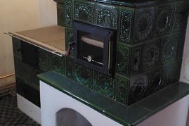 Kachlový sporák, ručně vyráběné kachle zelené barvy, prosklené topeniště a trouba